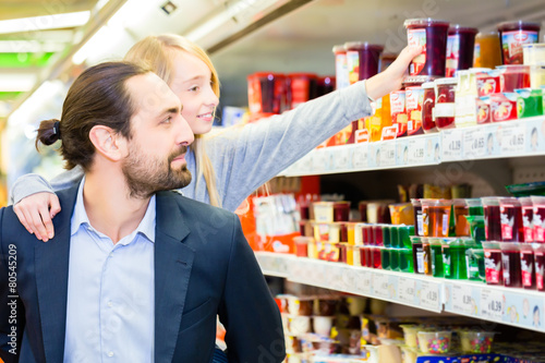 Family buying dessert in hypermarket © Kzenon