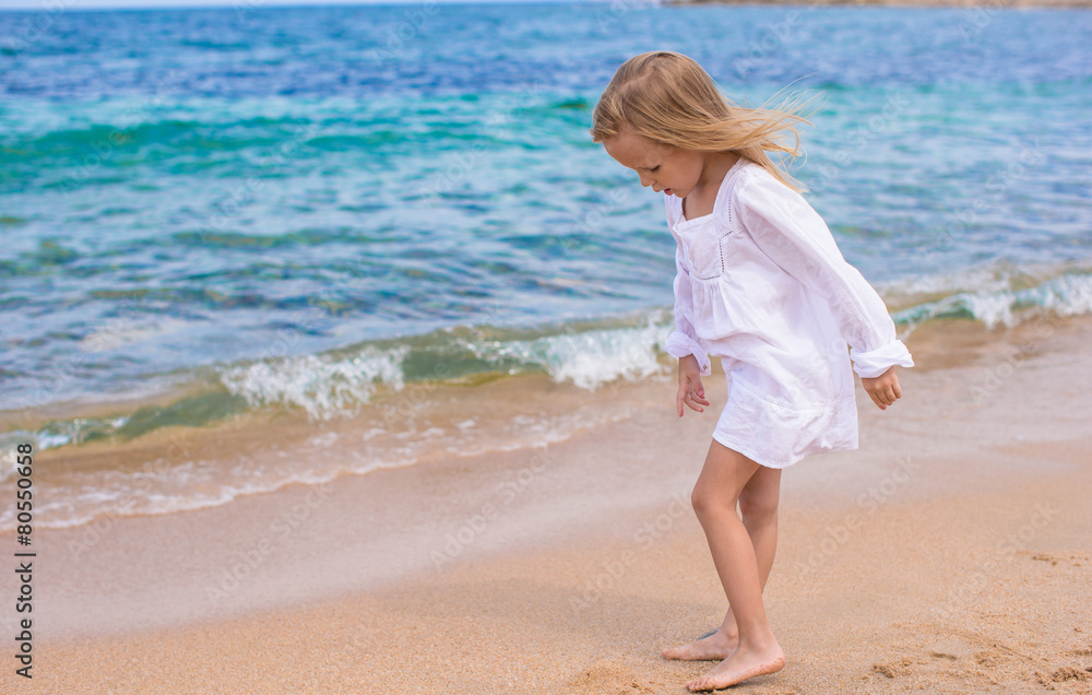 Adorable little girl have fun at tropical beach during vacation Adorable little girl have fun at tropical beach during vacation