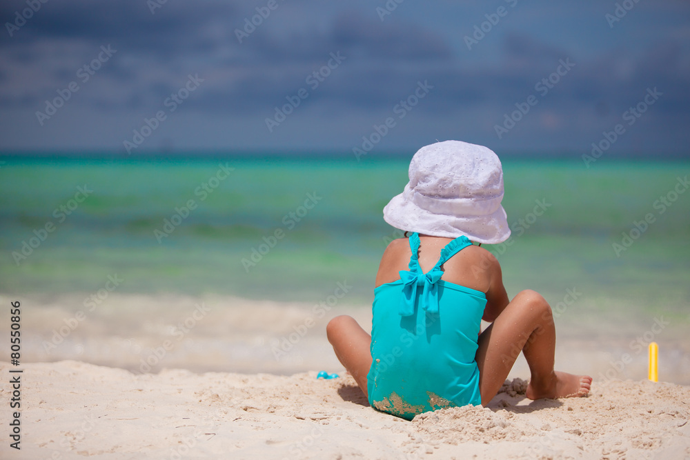Adorable little girl playing at tropical beach during vacation Adorable little girl playing at tropical beach during vacation