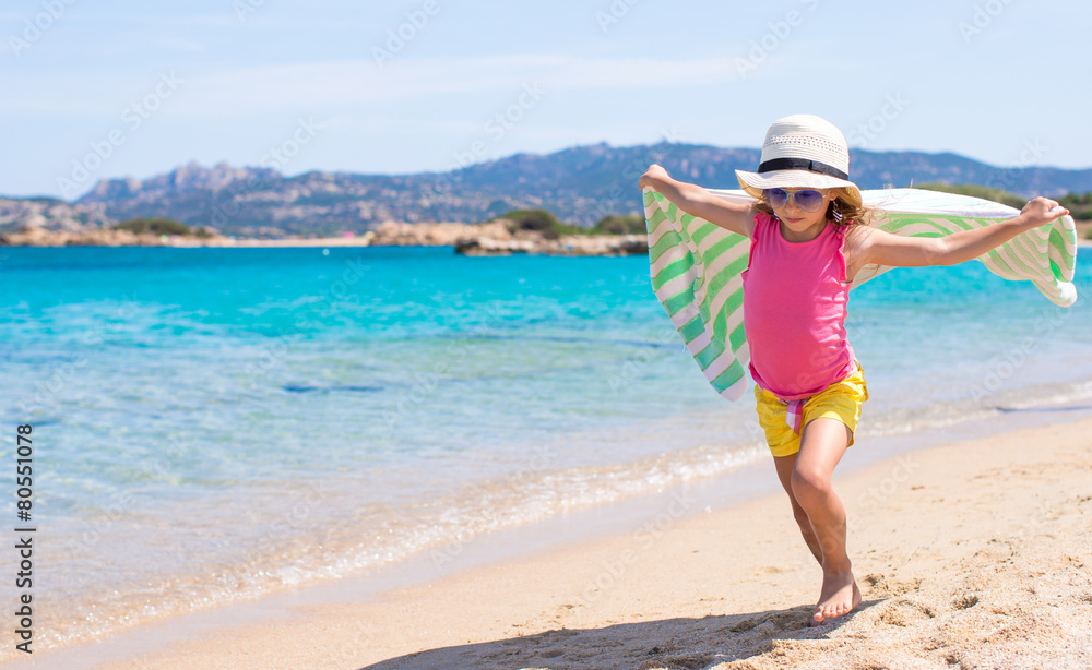 Little happy girl running on beach with towel Little happy girl running on beach with towel