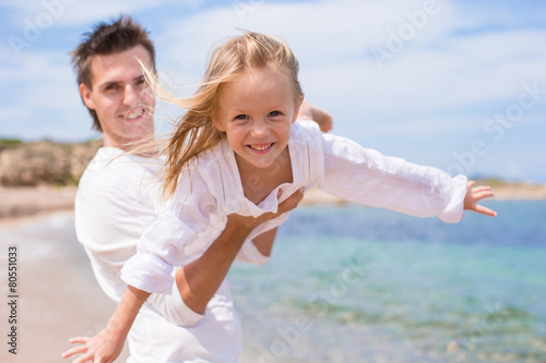 Happy father and little girl have fun during beach vacation