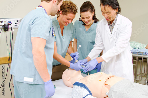 Medical staff practicing intubating mannequin