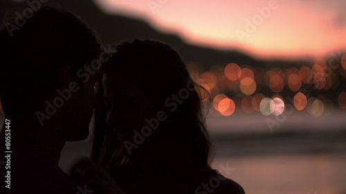 Silhouette of loving couple kissing on the beach