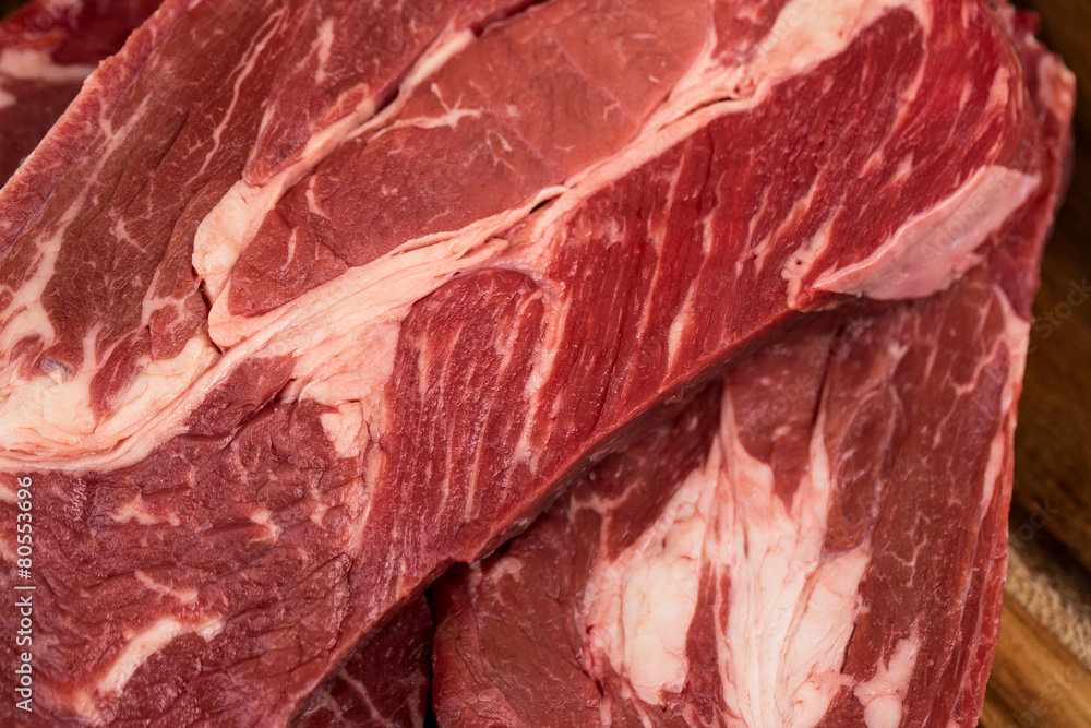Fresh beef steaks on wooden board Fresh beef steaks on wooden board