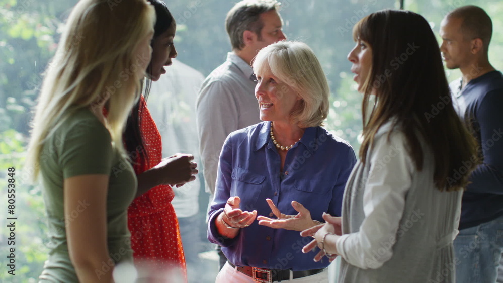 Female friends or casual business colleagues chatting together at a social event