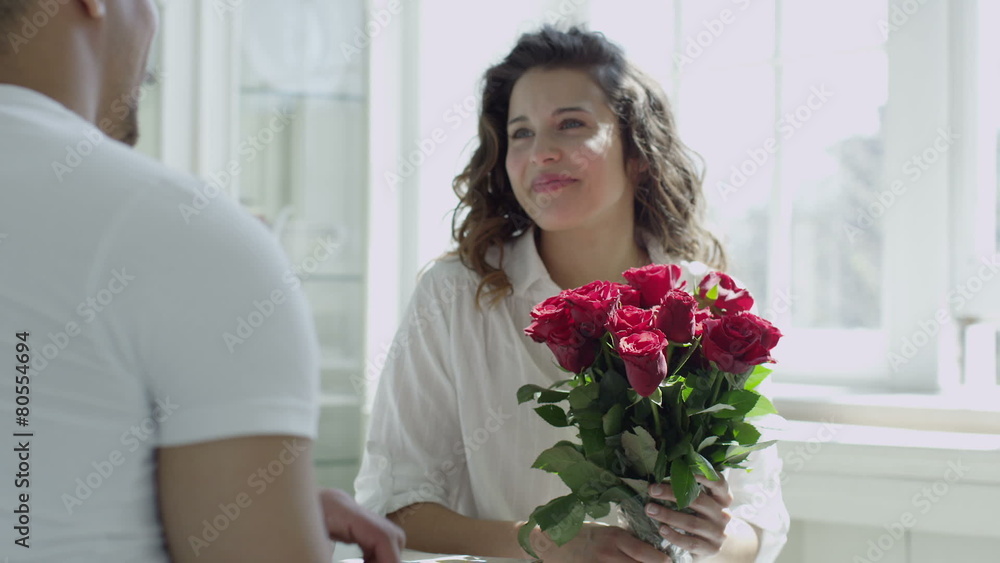 Man surprises his wife or girlfriend with bouquet of red roses Man surprises his wife or girlfriend with bouquet of red roses