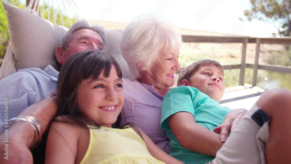 Grandparents spending time with their grandchildren in hammock Grandparents spending time with their grandchildren in hammock