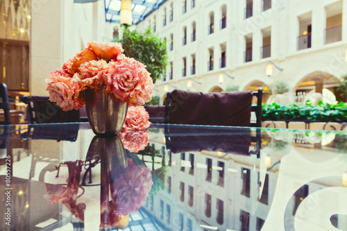 Flowers on glass table with reflection