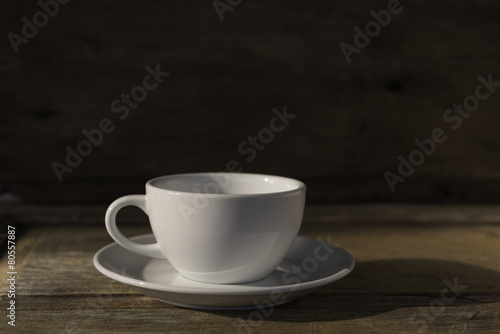 Cup of coffee on grunge wood table in vintage style