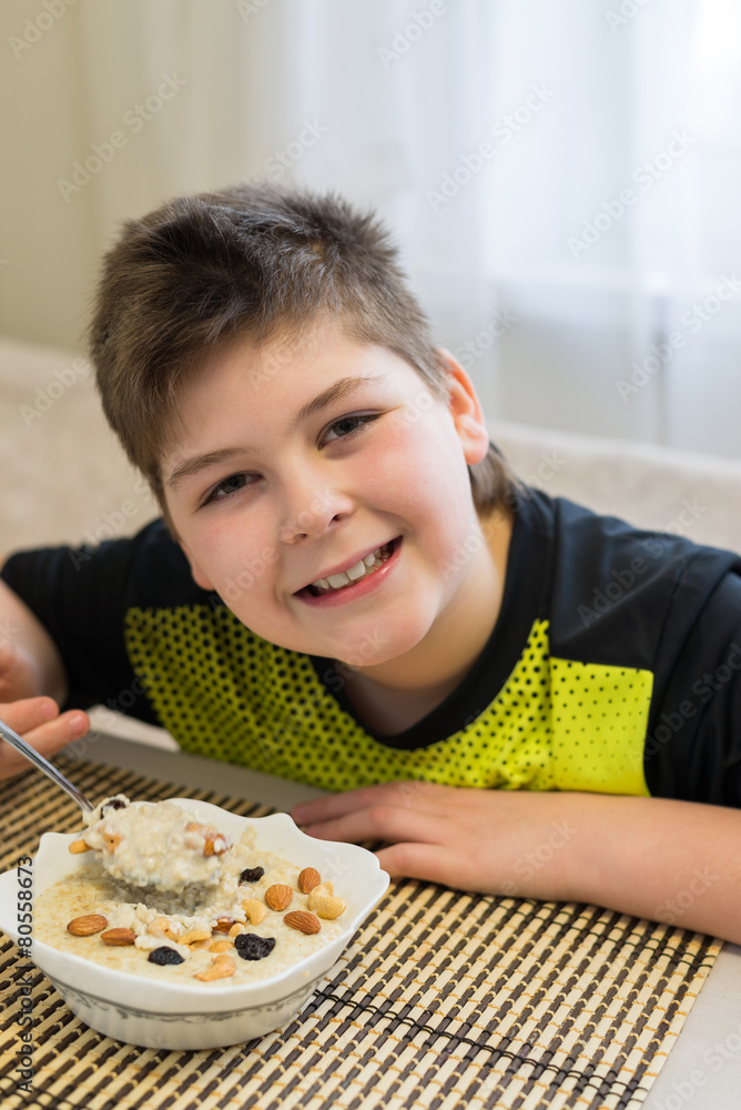 Teenager boy has oatmeal for breakfast