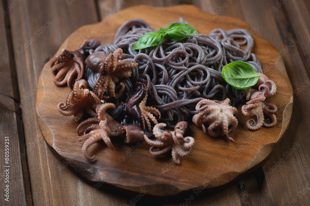 Black rice vermicelli with octopuses on a chopping board