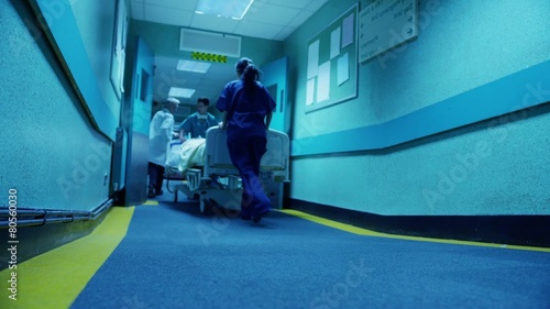 Hospital emergency team rush a patient on a gurney to the operating theatre photo