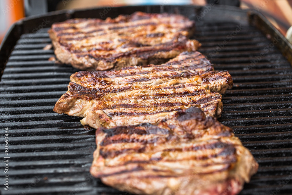 Beef steaks on grill or BBQ with spatula