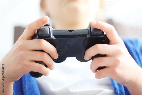 Dziecko trzyma w dłonie pilot do gry video.