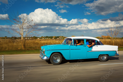 Old classic car on street of Cuba with white clouds and blue sky