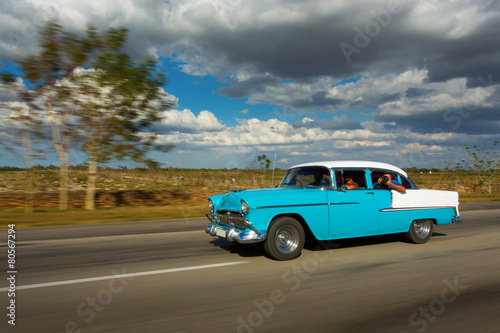 Old classic car on street of Cuba with white clouds and blue sky