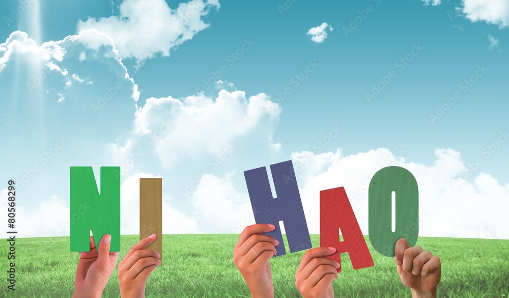Naklejka premium Composite image of hands holding up ni hao