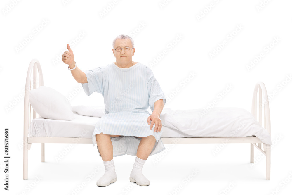 Mature patient sitting on a bed and giving thumb up
