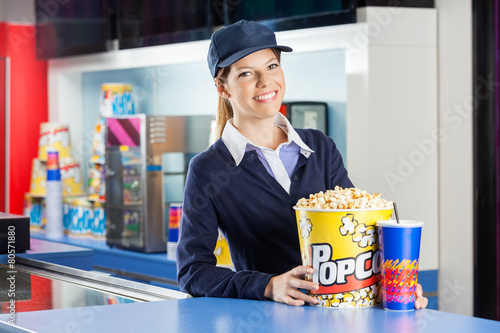 Billede på lærred Confident Worker With Popcorn And Drink At Concession Stand