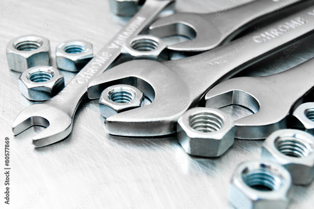 Fototapeta premium Wrenches and nuts on metal background.