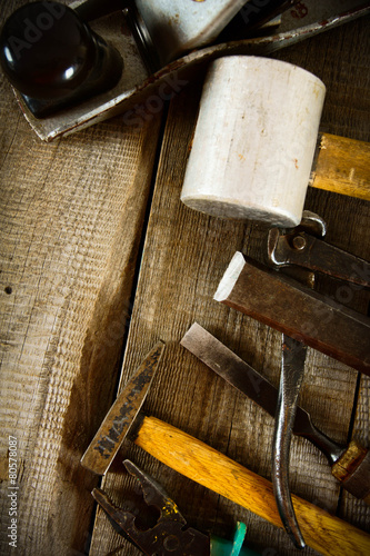 Many old working tools on a wooden background.