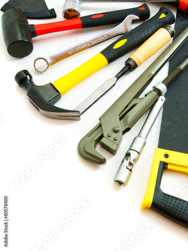 Many working tools - saw, axe, pliers and others on white