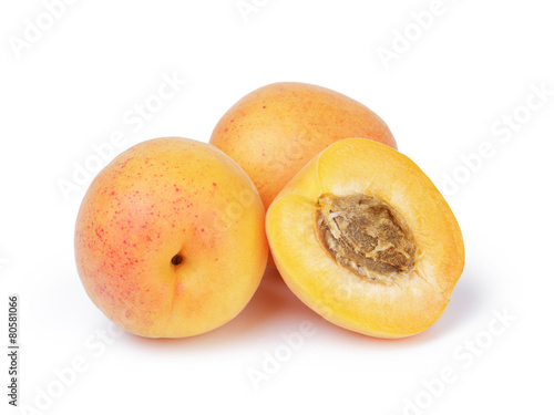 three ripe apricot fruits one half sliced isolated