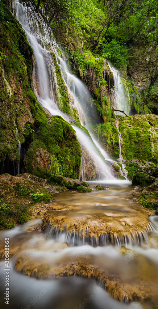 Beautiful waterfall among cliffs in spring time - obrazy, fototapety, plakaty 