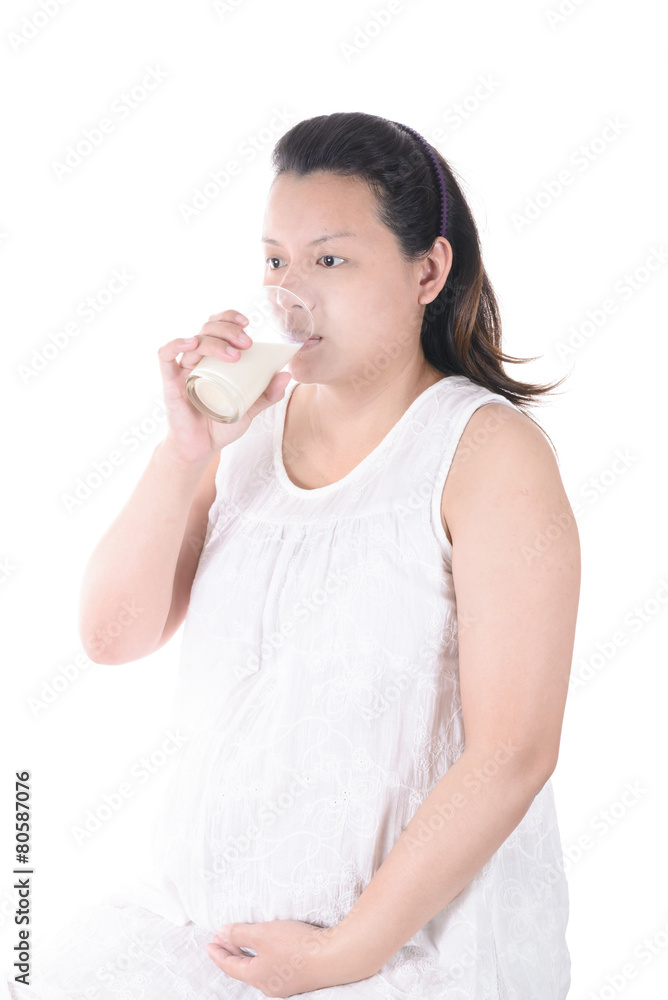 Pregnant Woman holding her pregnant belly and get a glass of mil Pregnant Woman holding her pregnant belly and get a glass of mil