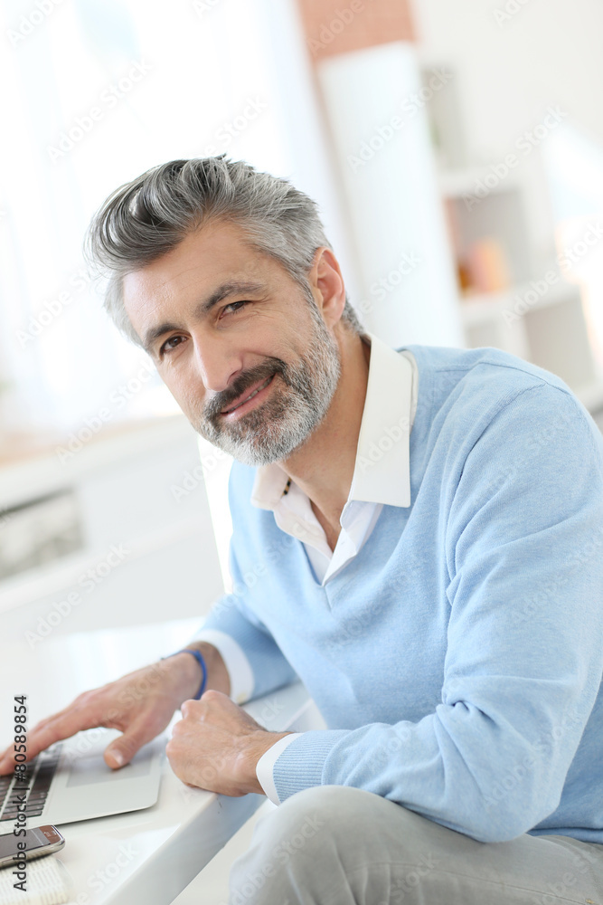 Trendy mature man working from home with laptop Trendy mature man working from home with laptop