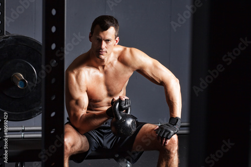 Man sitting and holding a kettlebell - crossfit