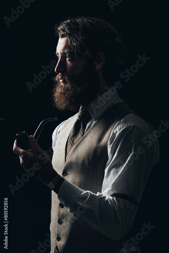 Elegant Young Handsome Guy Holding a Smoking Pipe