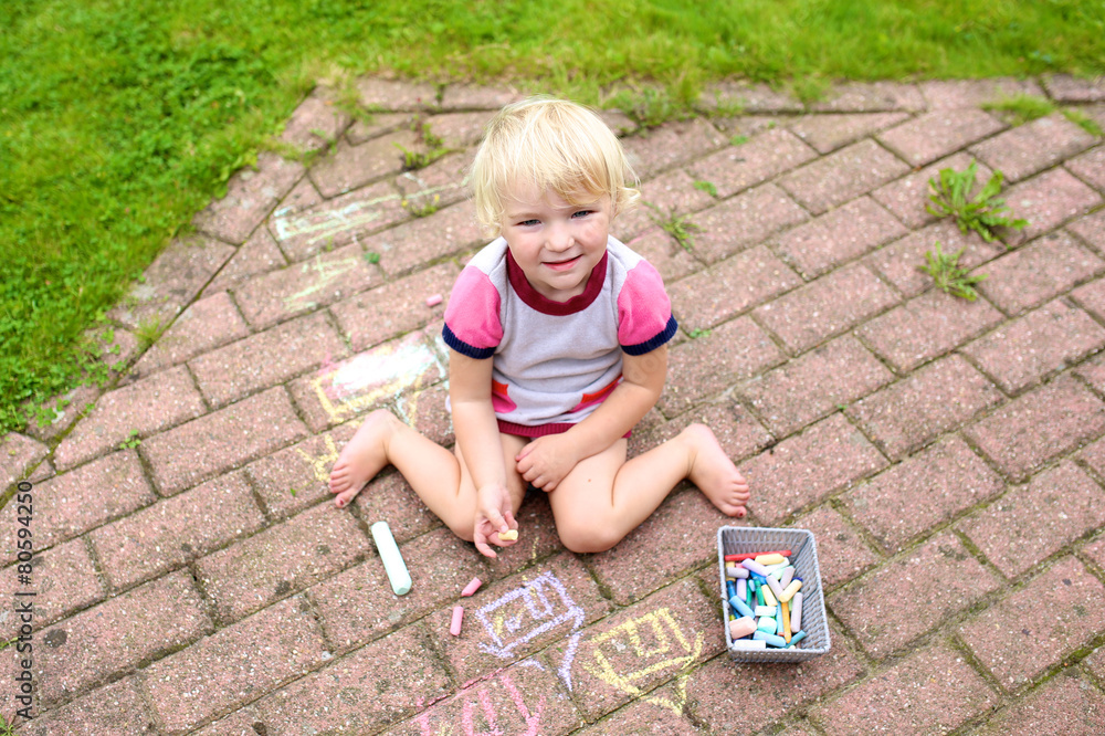 Little girl drawing with chalk at the backyard of the house Little girl drawing with chalk at the backyard of the house