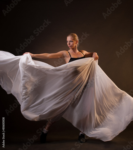 beautiful woman in motion holding fabric