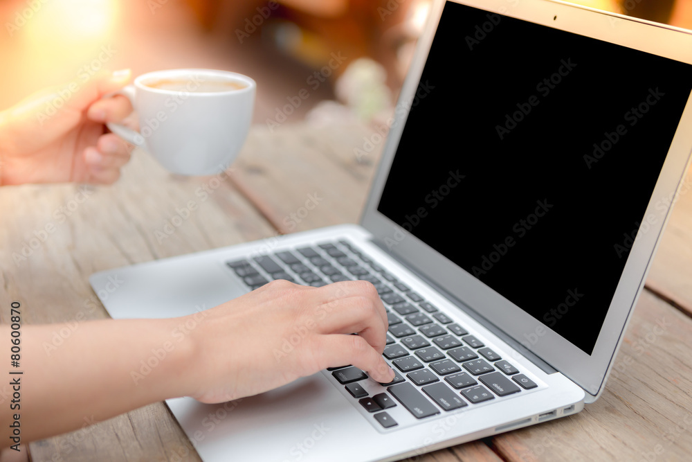Closeup of business woman hand typing on laptop keyboard and cof Closeup of business woman hand typing on laptop keyboard and cof