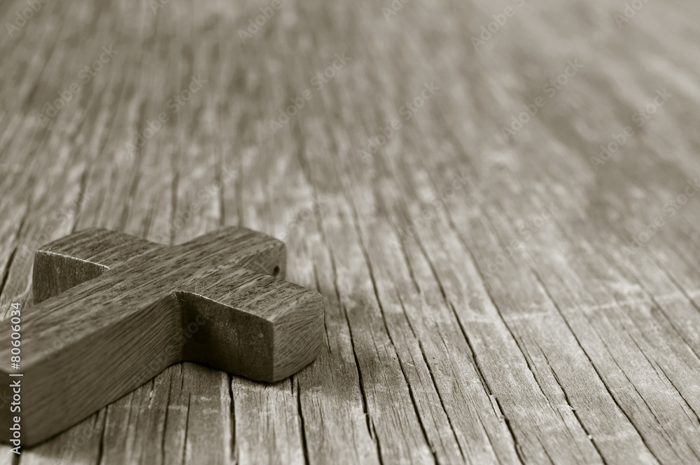 wooden Christian cross on a rustic wooden surface, sepia toning foto de