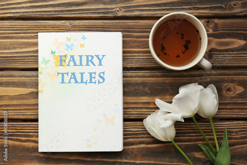 Fairy Tales book with cup of tea and white tulips