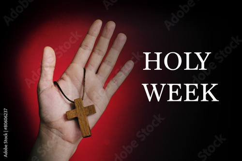 man hand with a wooden cross and the text holy week photo