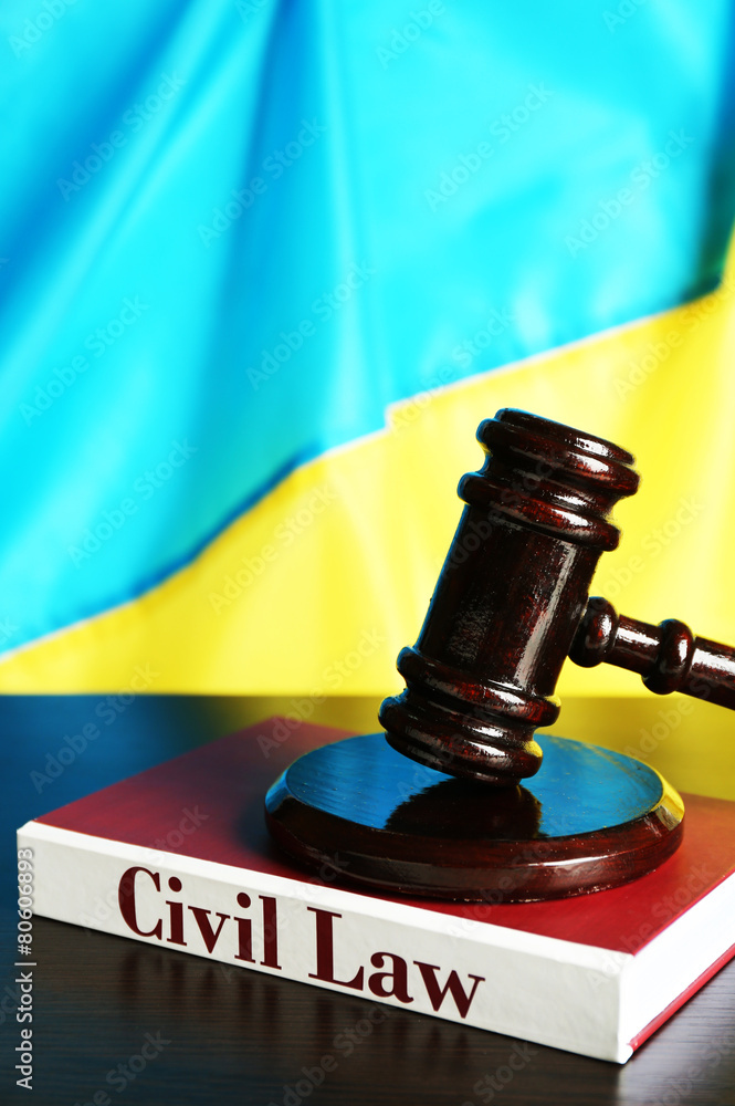 Wooden gavel and flag of Ukraine as background