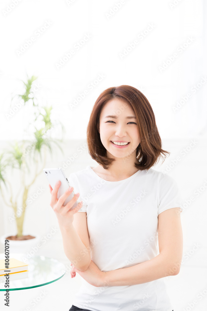 部屋でスマホを見る女性 部屋でスマホを見る女性