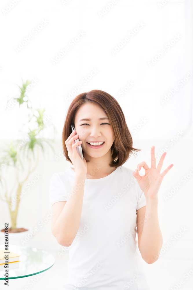 部屋で電話をする女性 部屋で電話をする女性