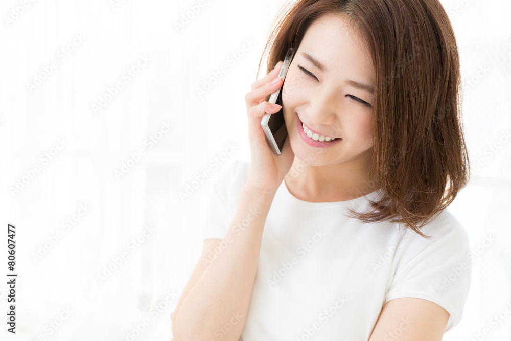 部屋で電話をする女性 部屋で電話をする女性