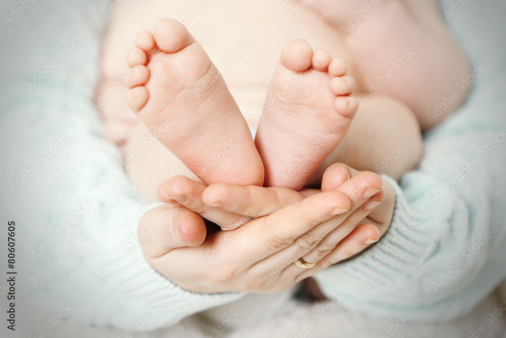 Newborn baby feet on female hands, close-up Newborn baby feet on female hands, close-up