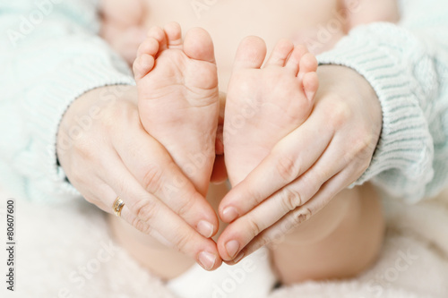 Newborn baby feet on female hands, close-up © Africa Studio