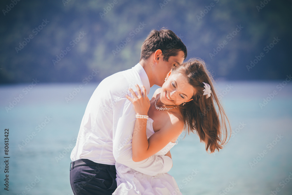 groom embrace bride standing on sand beach groom embrace bride standing on sand beach