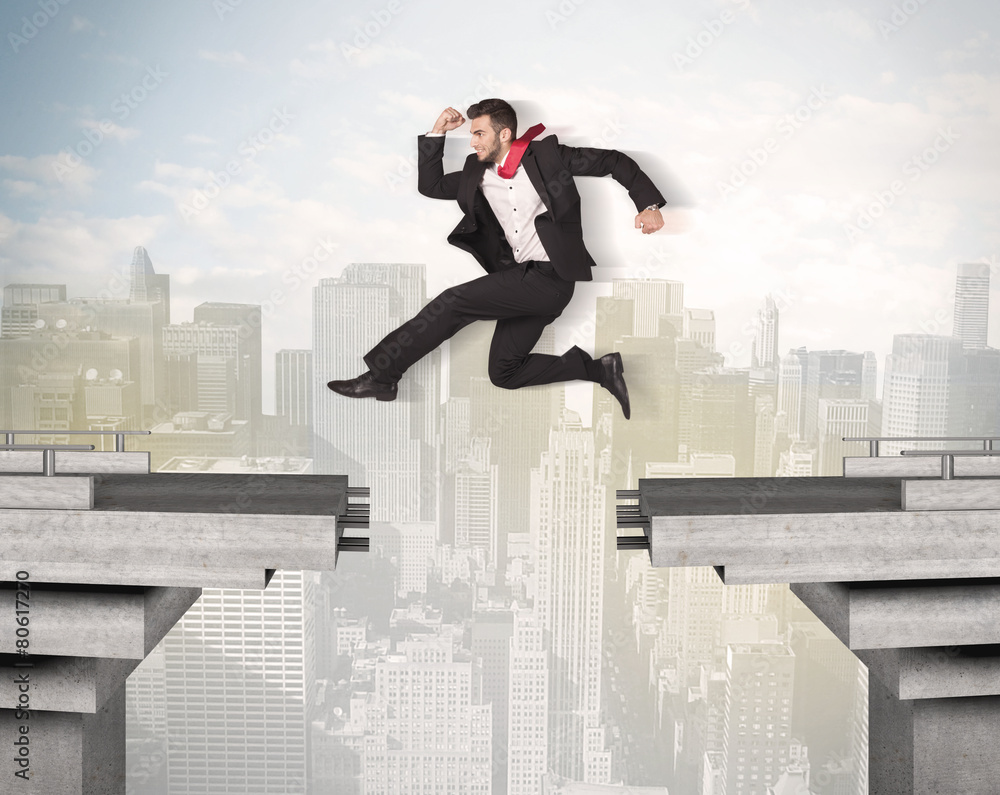 Energetic business man jumping over a bridge with gap Energetic business man jumping over a bridge with gap