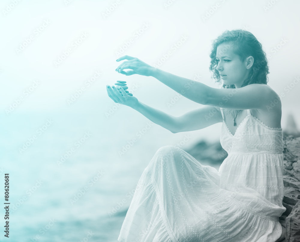 Woman holding zen stones in hand. With blue light effect. Woman holding zen stones in hand. With blue light effect.