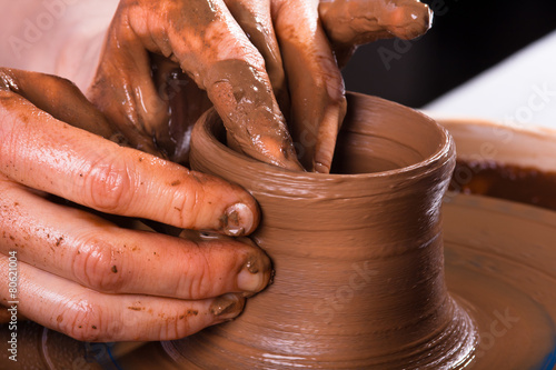 closeup of hands working on pottery wheel