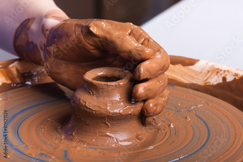 hand of potter with clay jug