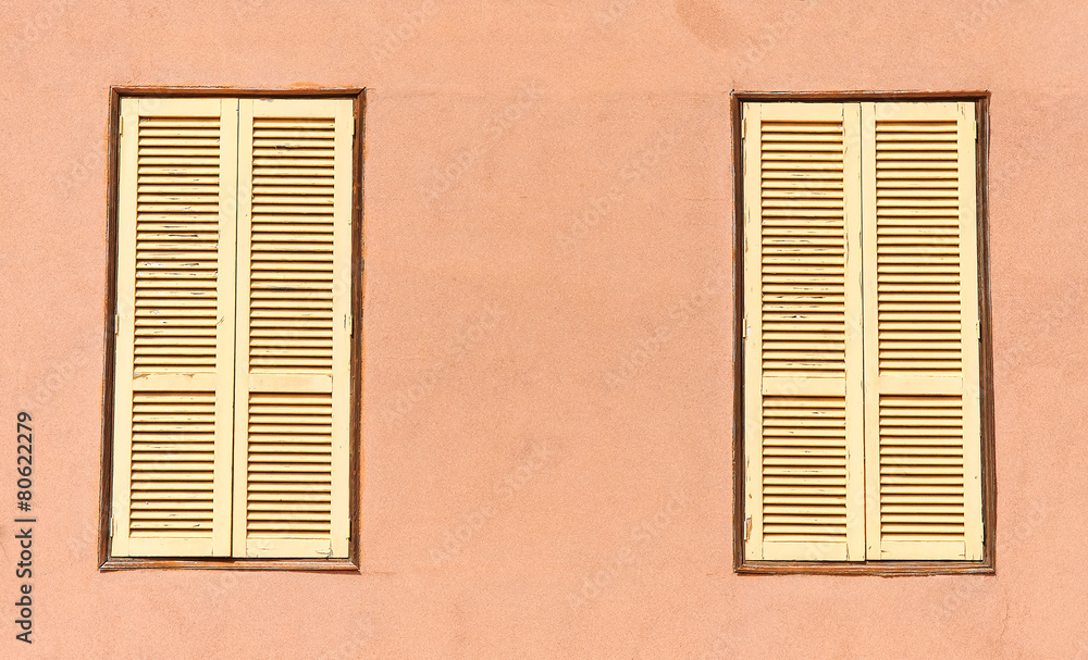 Two window with yellow shutters. Close-up view. Two window with yellow shutters. Close-up view.